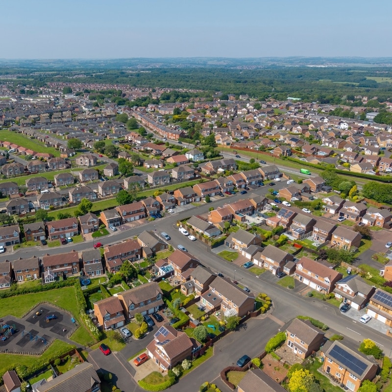 Bird's-eye view of a housing estate in the North East of England, displaying clusters of homes and nearby greenery.